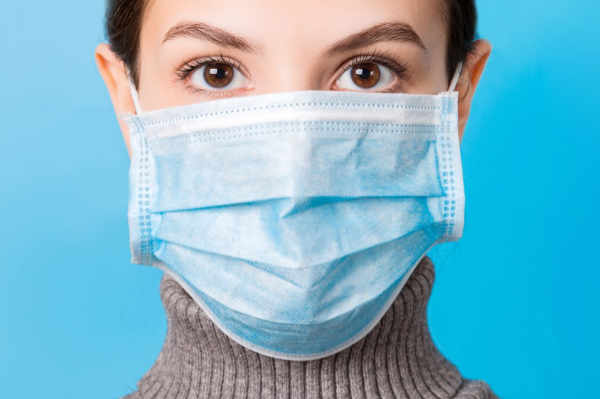  girl wearing surgical mask as a COVID precaution