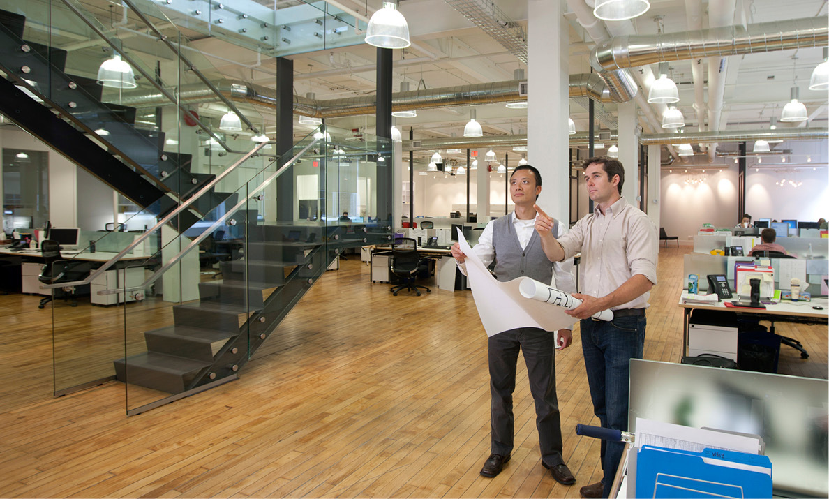 2 men discuss lighting plans in office